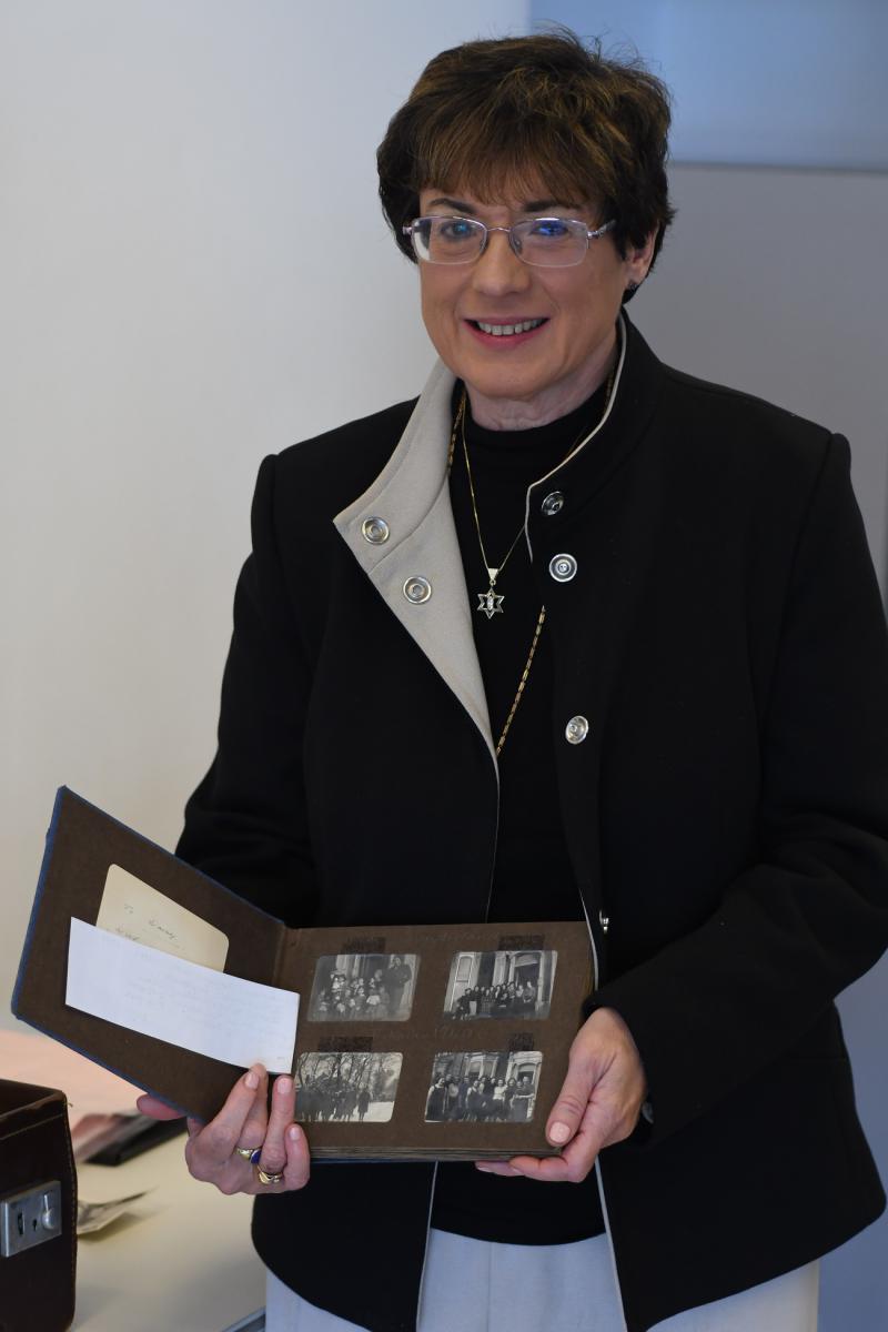 Susan Herold with her mother's photo album at Yad Vashem